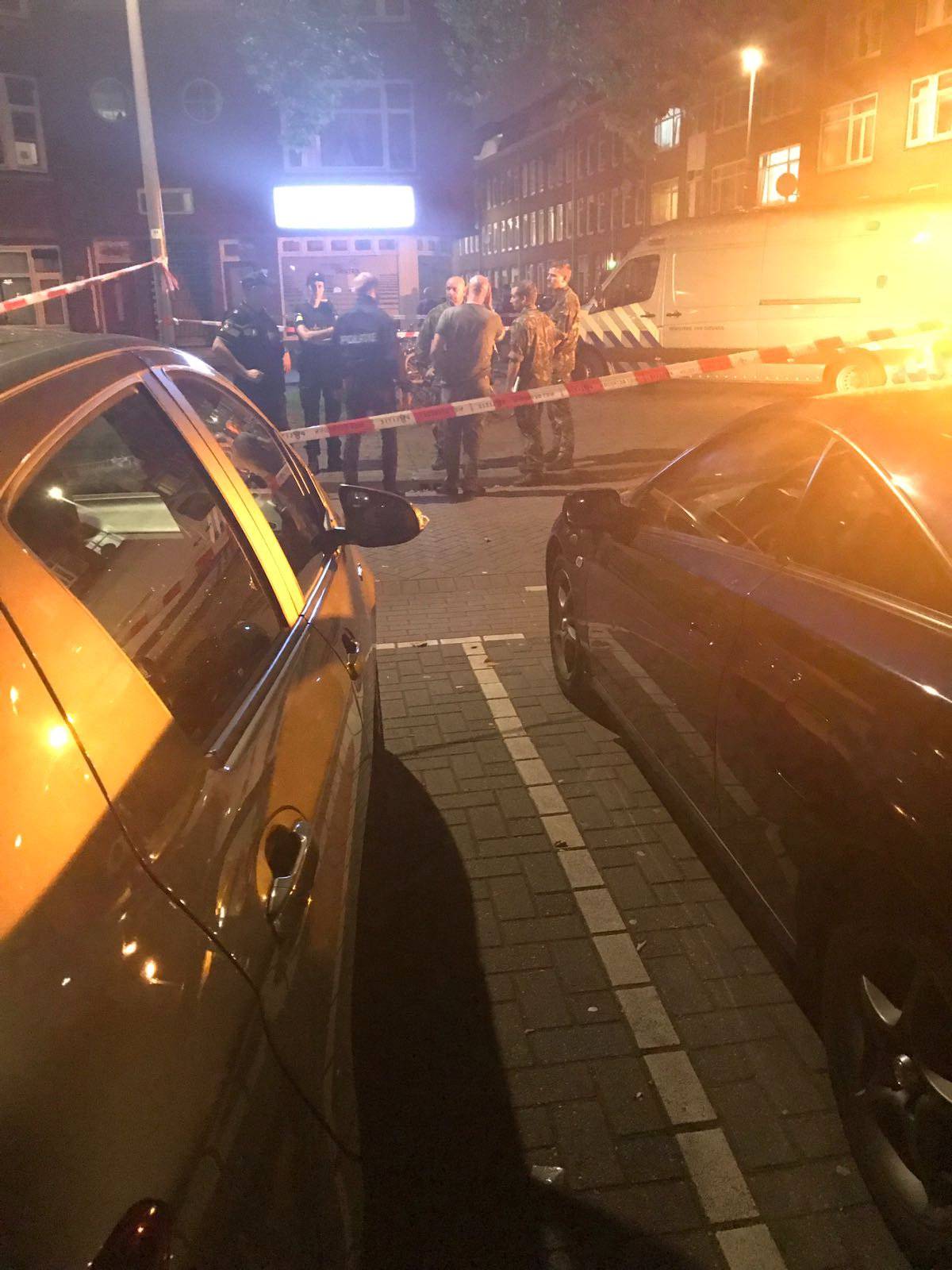People gather at the scene where police are investigating a van with Spanish licence plates containing gas bottles which was found near a concert hall in Rotterdam