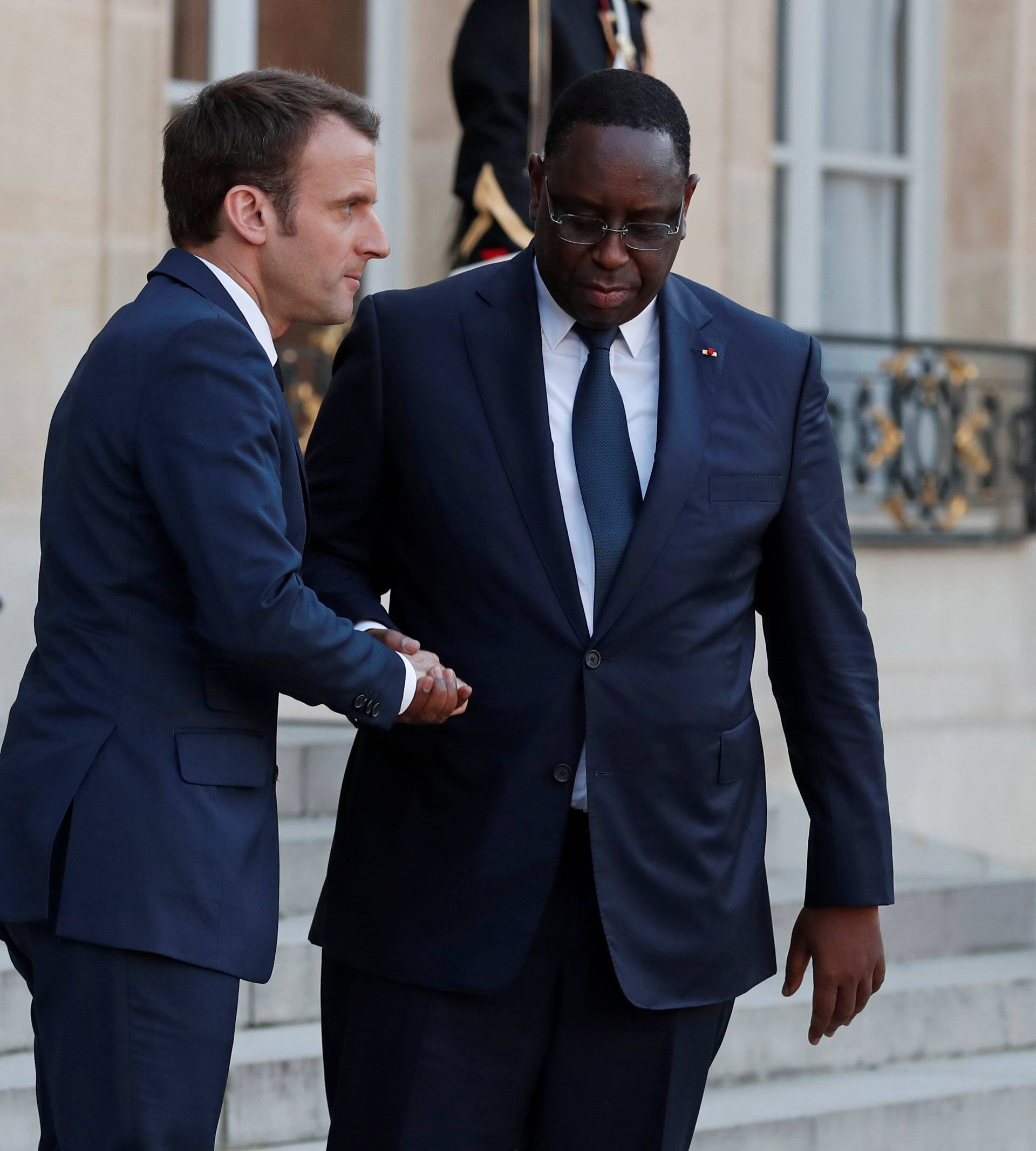 French President Emmanuel Macron accompanies Senegalese President Macky Sall as he leaves the Elysee Palace in Paris