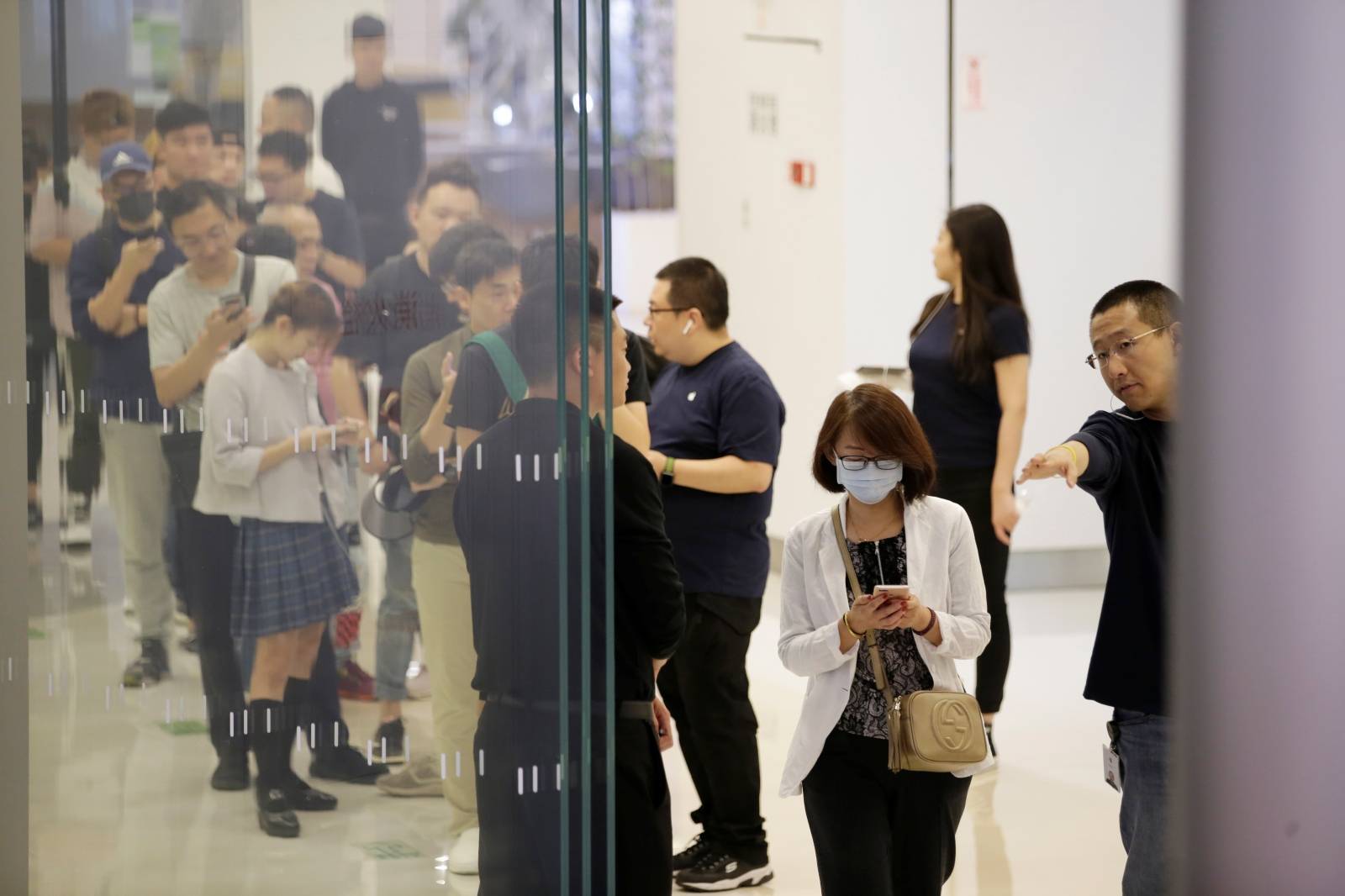 Customers wait to enter an Apple Store after Apple's new iPhone 11, 11 Pro and 11 Pro Max went on sale in Beijing