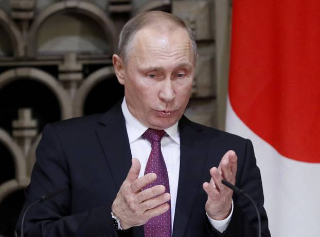 Russian President Vladimir Putin gestures as he speaks during a joint news conference with Japanese Prime Minister Shinzo Abe in Tokyo, Japan