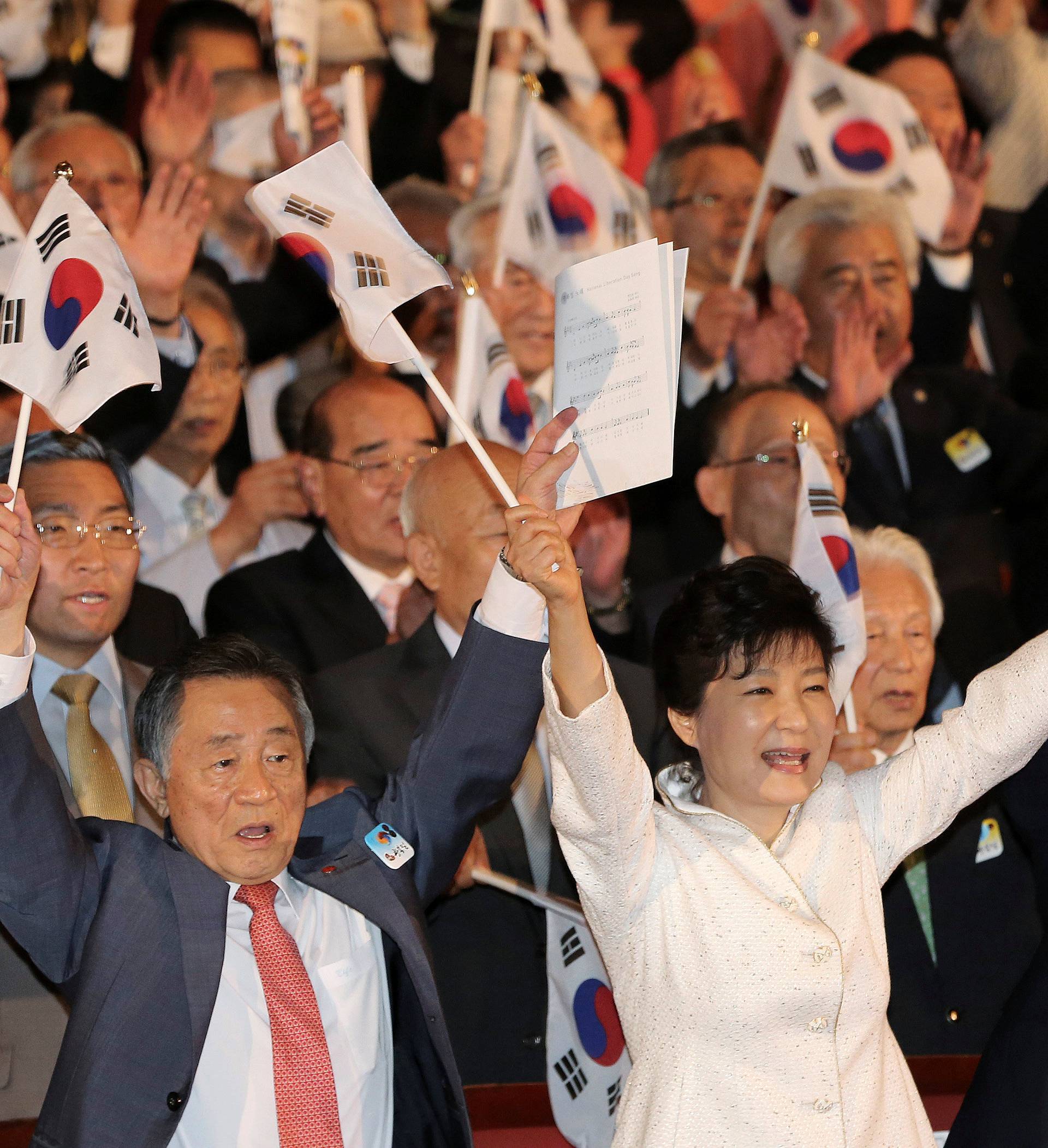 South Korean President Park Geun-hye gives three cheers for the country during a ceremony marking the 69th anniversary of liberation from Japan's 1910-45 colonial rule, on Liberation Day in Seoul