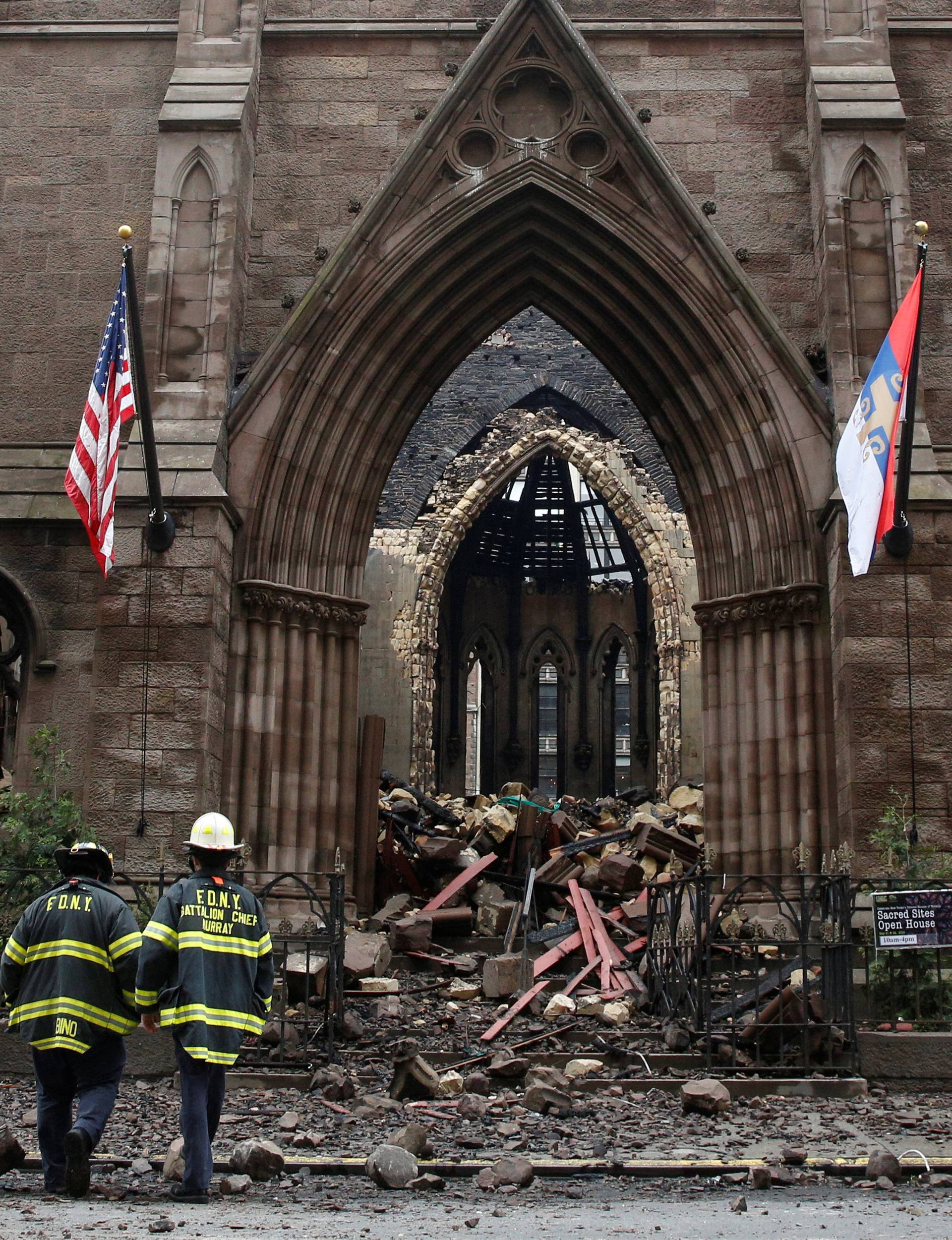 New York City firefighters (FDNY) walk through the debris following a fire at Manhattan's historic Serbian Orthodox Cathedral of Saint Sava in New York 