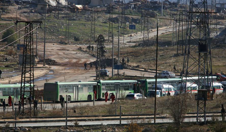 Buses and ambulances wait to evacuate civilians and rebels from eastern Aleppo