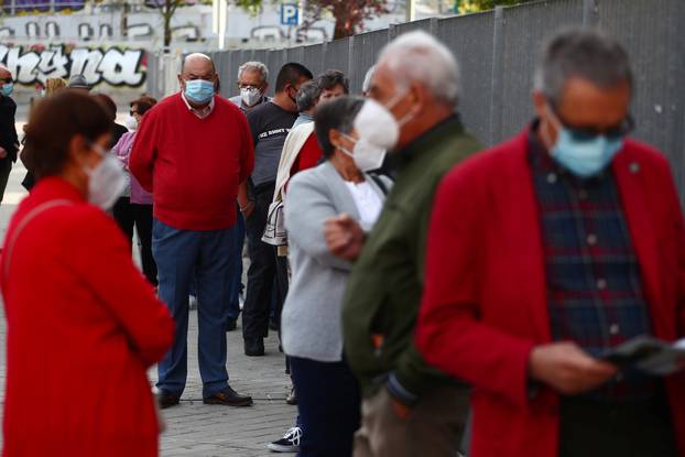 People wait in a queue outside a cultural centre before a coronavirus disease (COVID-19) antigen test in Madrid