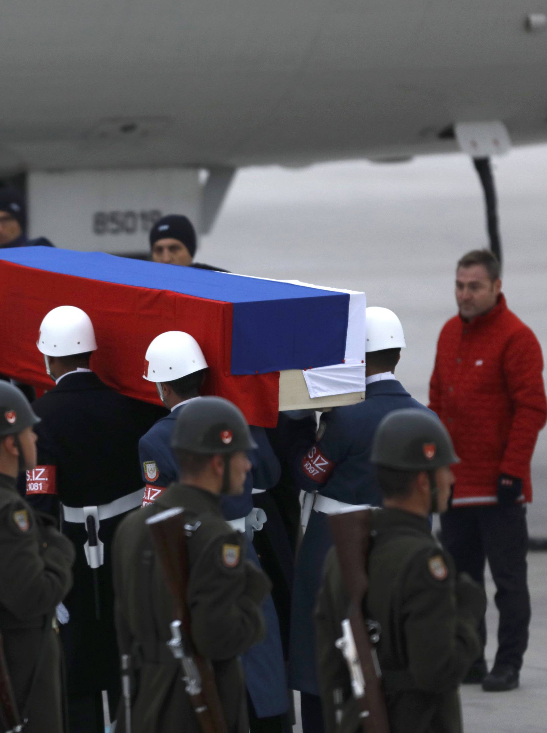 Flag-wrapped coffin of late Russian Ambassador to Turkey Karlov is carried to a plane during a ceremony at Esenboga airport in Ankara