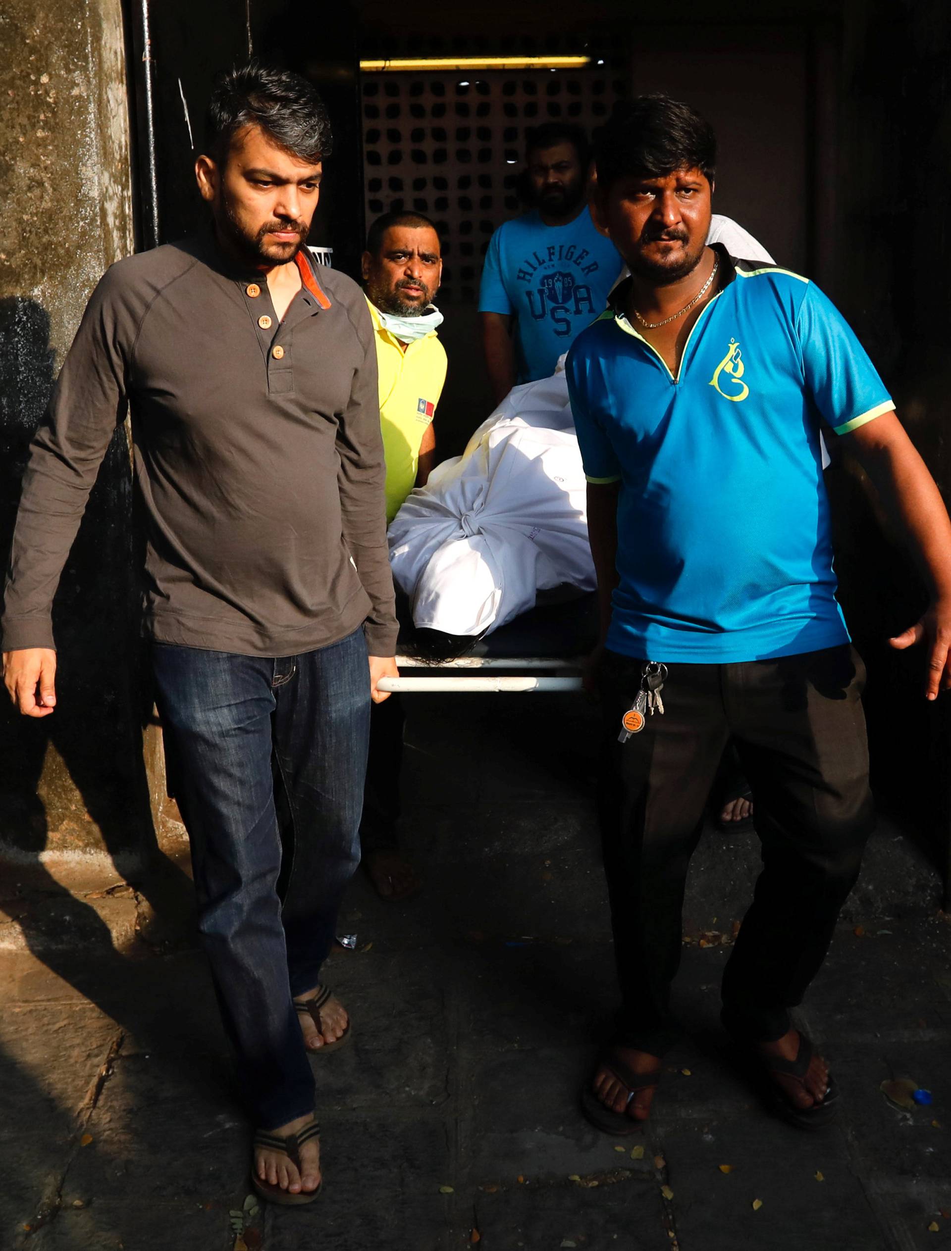 Family members and friends carry the body of a victim killed in a fire at a restaurant from a hospital in Mumbai