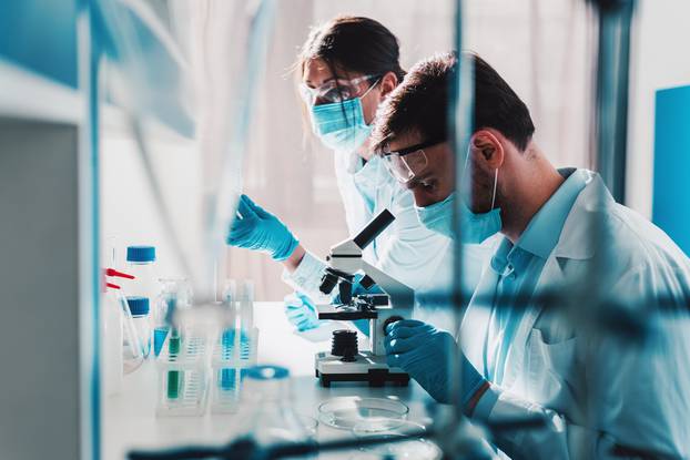 Doctor in the laboratory analyzes samples of codiv-9 under a microscope