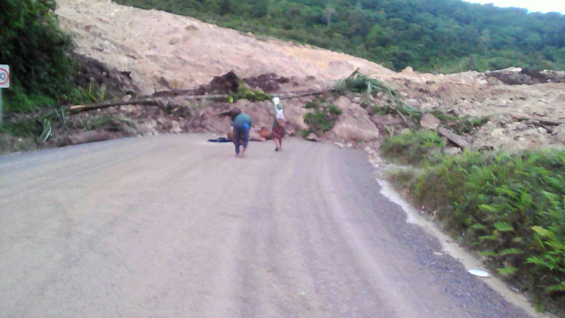 A supplied image shows locals inspecting a landslide and damage to a road located near the township of Tabubil after an earthquake that struck Papua New Guinea's Southern Highlands
