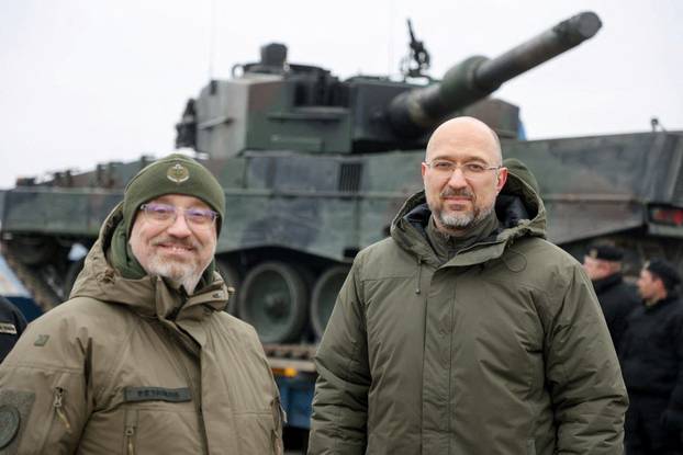 Ukrainian PM Shmyhal and Defence Minister Reznikov stand next to the first Leopard 2 tanks delivered from Poland, in an undisclosed location in Ukraine