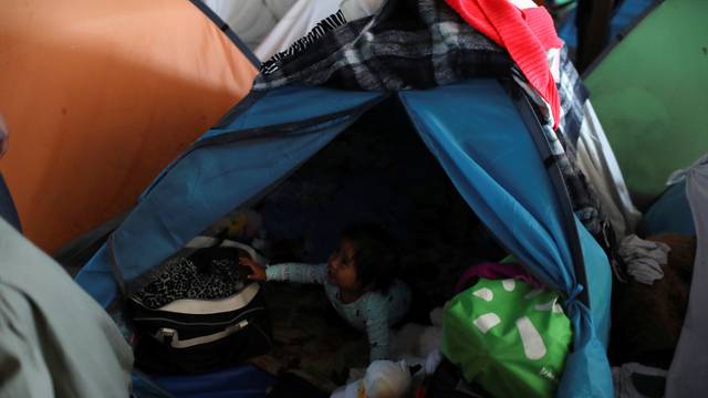A child, who is part of the Central American migrants moving in a caravan through Mexico and travelling to request asylum in the U.S., is seen inside a tent at a shelter in Tijuana