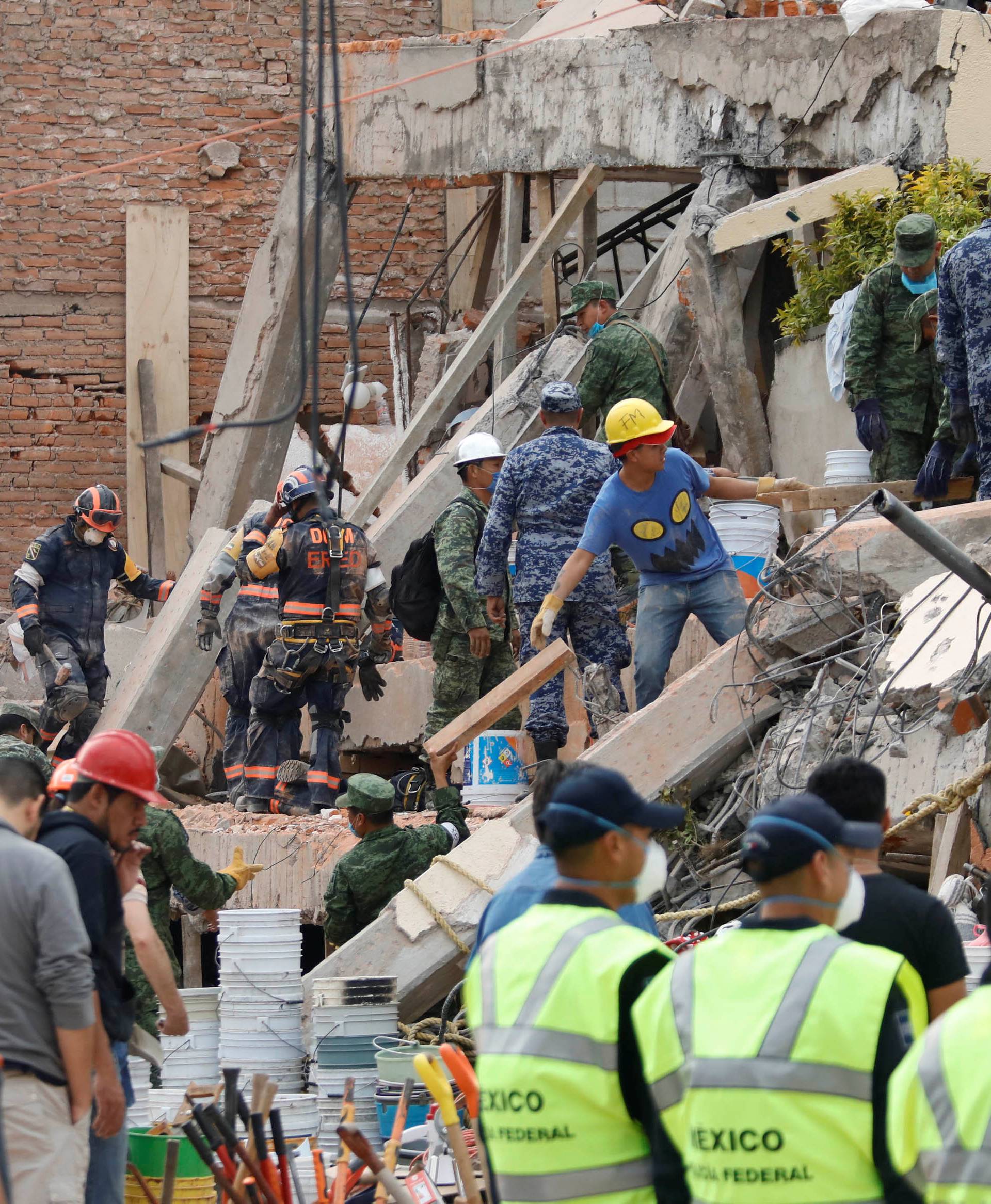 Rescue workers search through the rubble for students at Enrique Rebsamen school in Mexico City