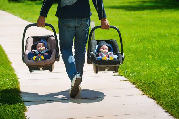 Father,Carrying,Twin,Babies,In,Car,Seats.,Family,Time,Together.