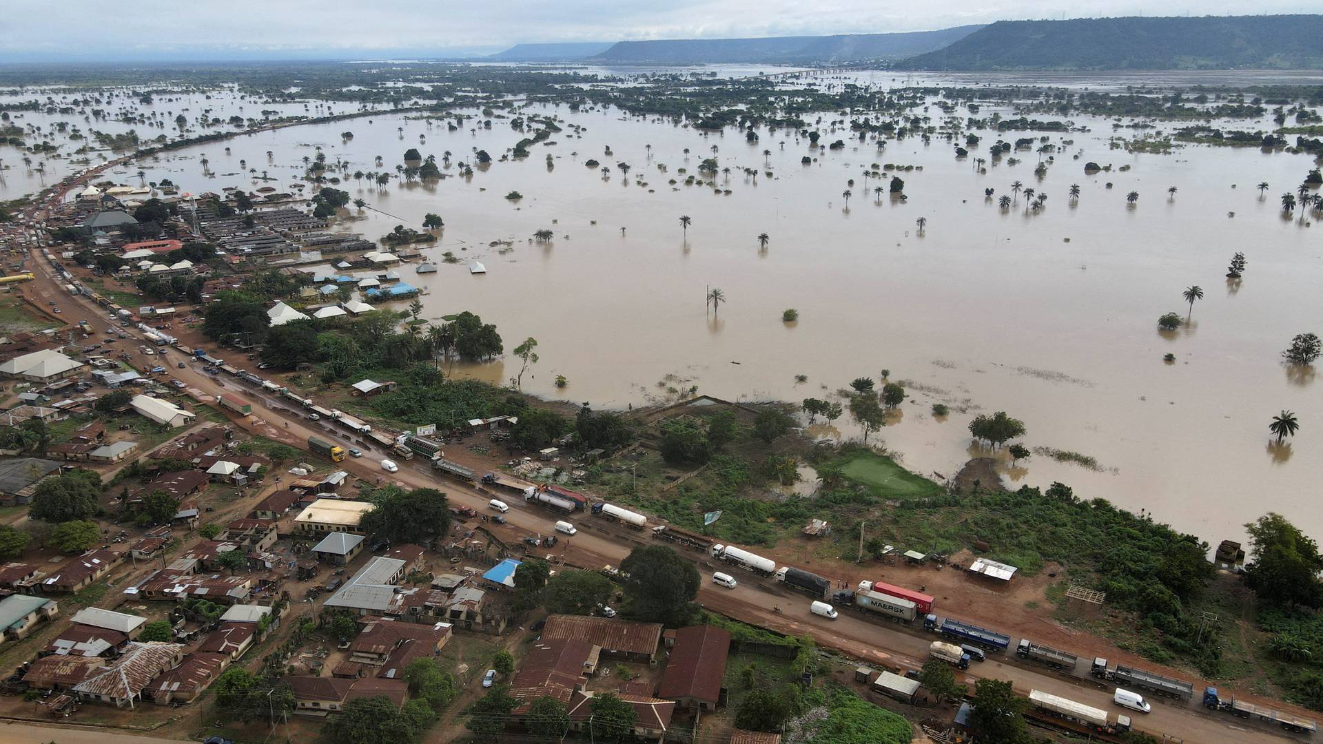 Vehicles are seen on a flooded road in Lokoja