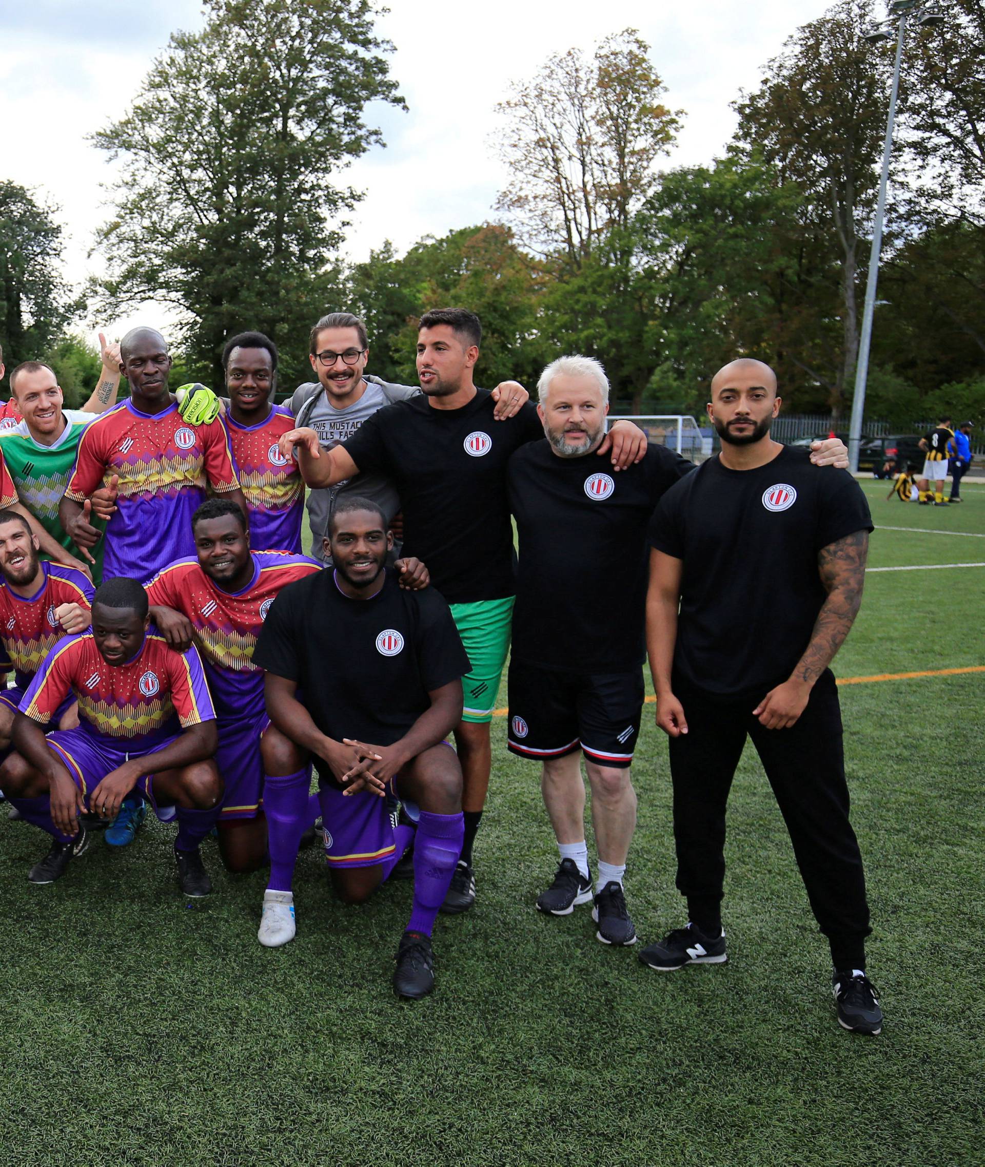 Clapton CFC players pose for pictures after winning their away game against Ealing Town in East Acton, in London