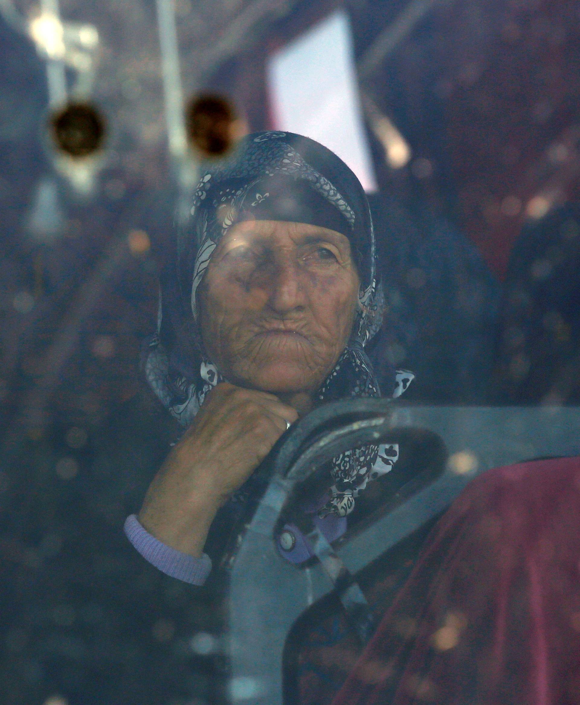 A migrant woman sits inside a bus during a police operation to evacuate a migrants' makeshift camp at the Greek-Macedonian border near the village of Idomeni