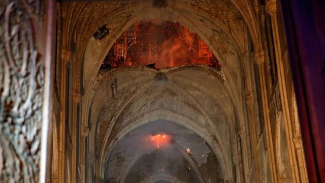 Flames are seen as the interior continues to burn inside the Notre Dame Cathedral in Paris