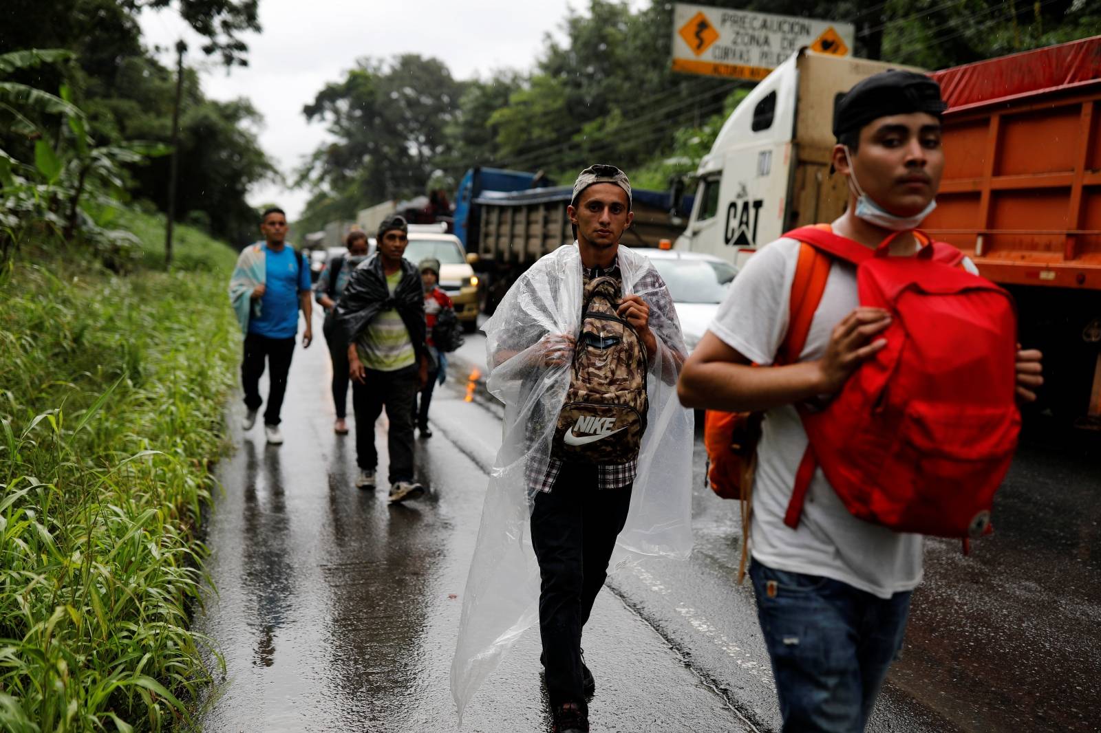 Honduran migrants trying to reach the U.S. walk along a road after bursting through a border checkpoint to enter Guatemala illegally, in Izabal