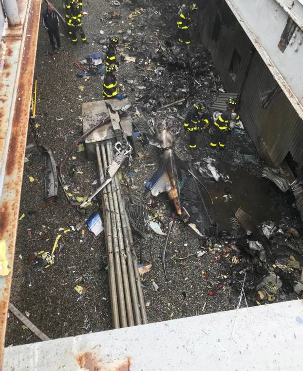 Handout photo of emergency crews surveying damage on a rooftop of a building after a helicopter crash in New York City