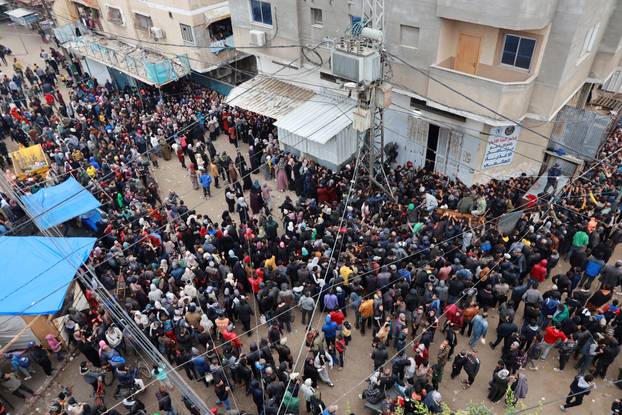 Palestinians gather to receive bread from a bakery in Deir Al-Balah