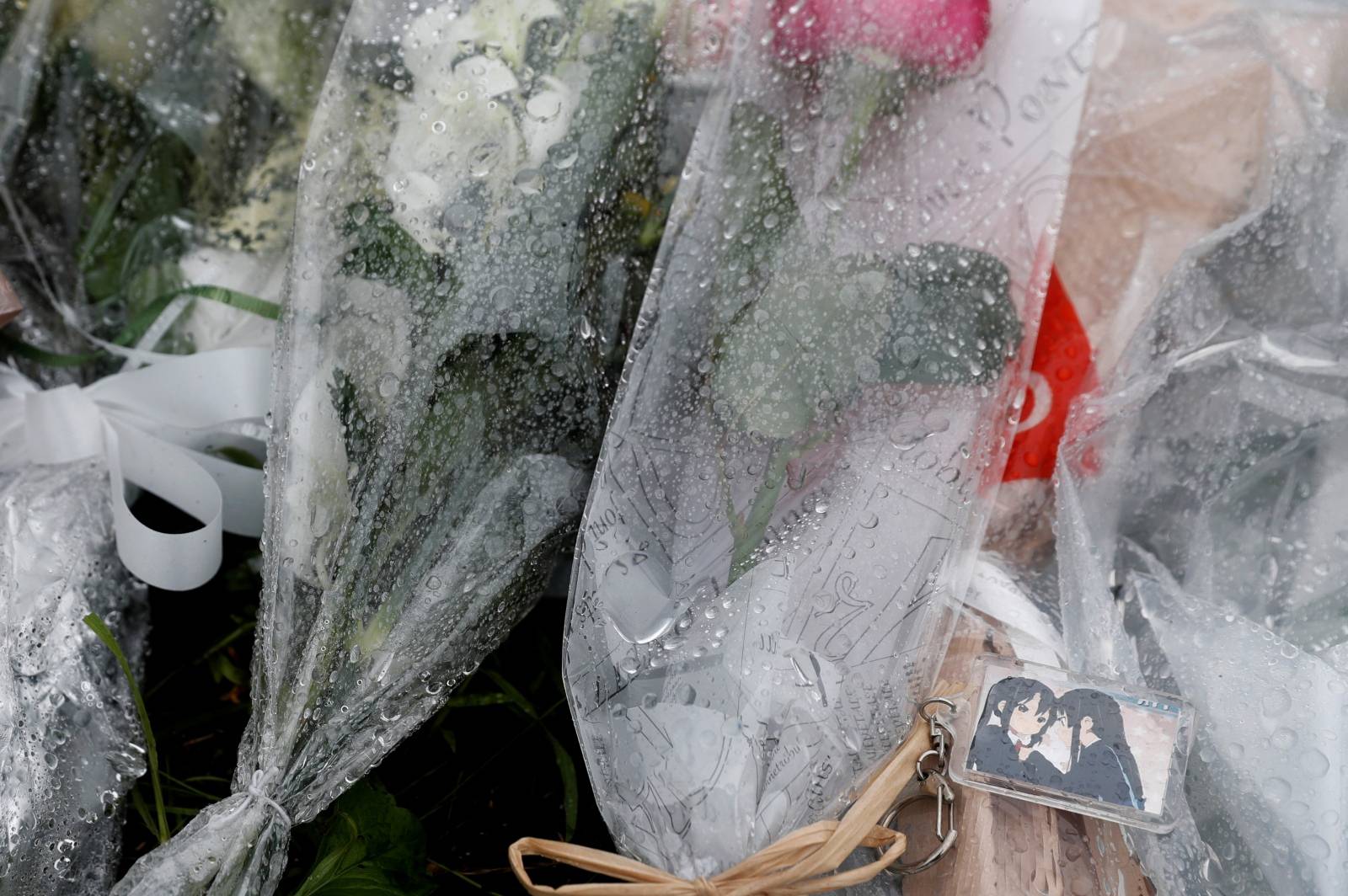 Flowers dedicated to the victims of the fire are seen left outside the Kyoto Animation building which was torched by arson attack, in Kyoto