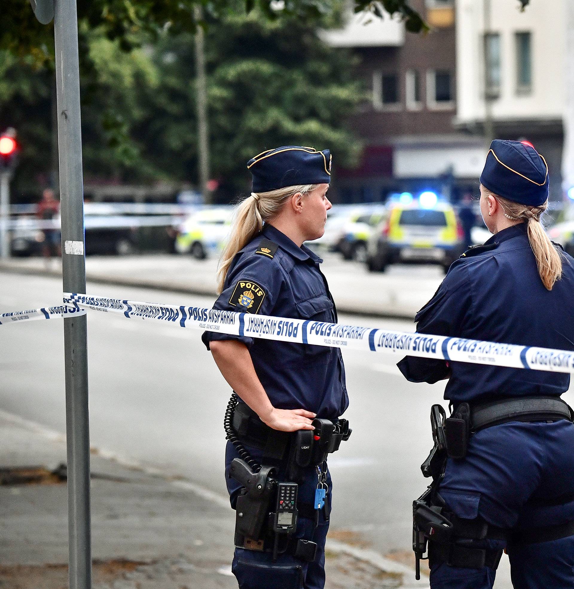 Police stand next to a cordon after a shooting on a street in central Malmo