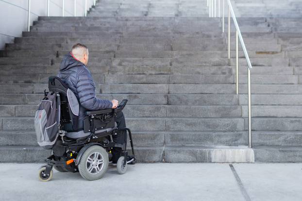 Man on a wheelchair looking at stairs