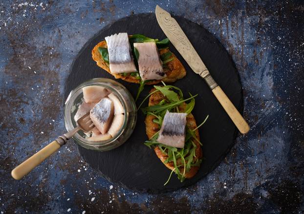 Herring sandwich (traditional Danish smorrebrod) on cutting boar