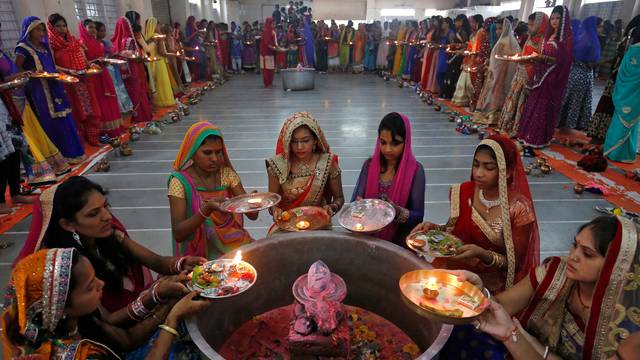 Hindu women perform a ritual known as Aarti around a Shivling (a symbol of Lord Shiva) on the last day of Jaya Parvati Vrat festival in Ahmedabad
