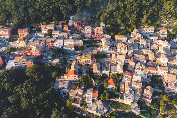 Beautiful aerial drone view of Lakones Village, traditional greek village near Paleokastritsa, Corfu island, Kerkyra, Ionian sea islands, Greece, in summer sunny day with blue sky and mountains 