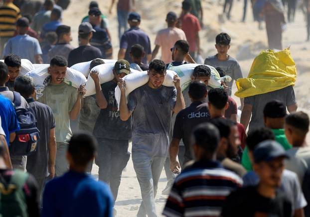 Palestinians gather to receive aid supplies amid a hunger crisis, in Beit Lahia