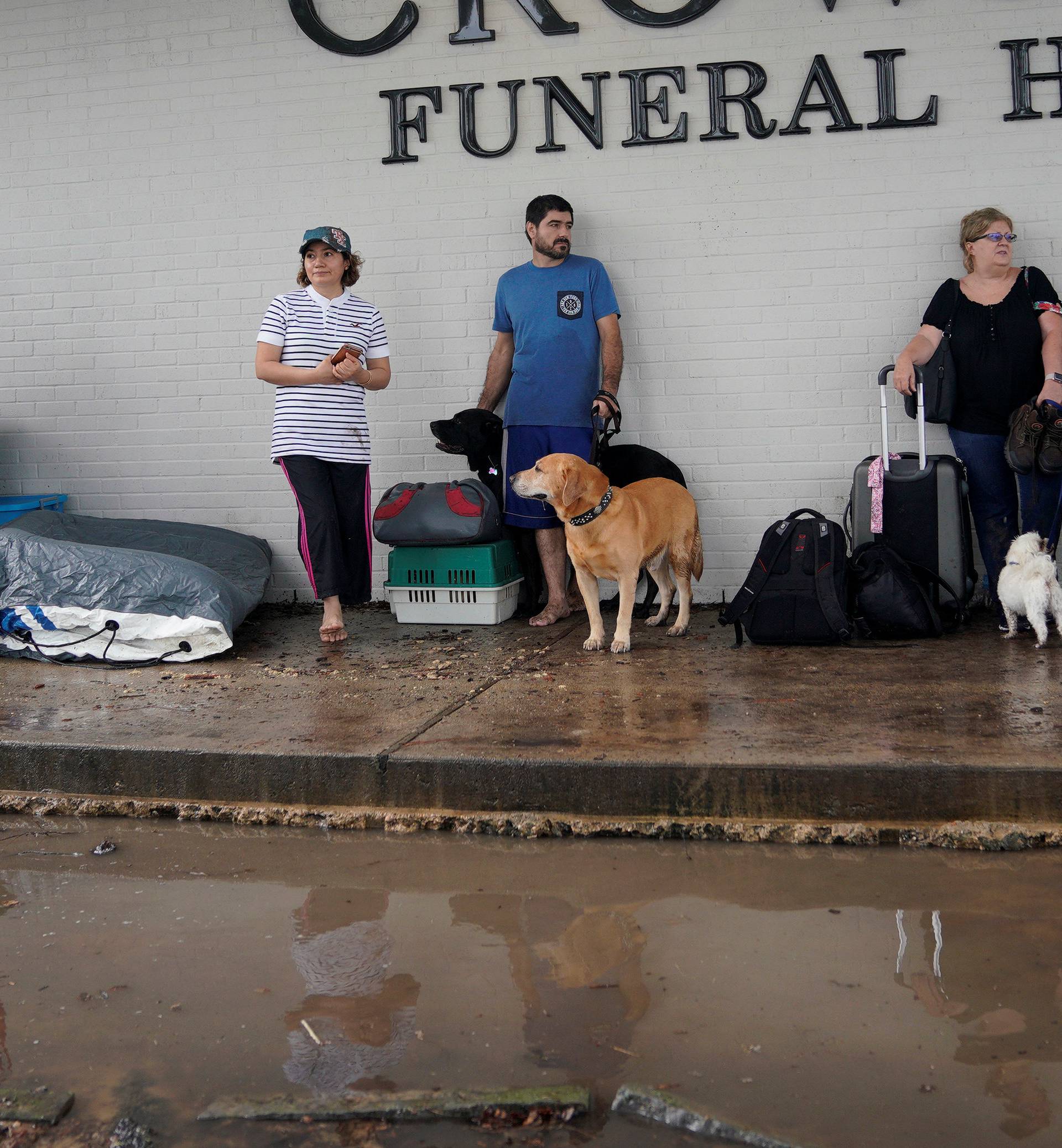 People wait outside a funeral home to evacuate from flood waters from Hurricane Harvey in Dickinson