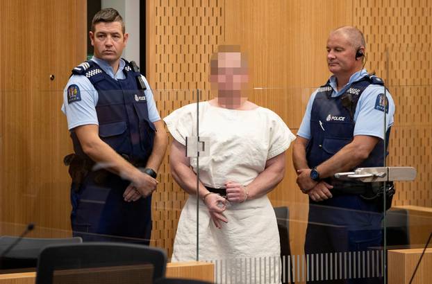 Brenton Tarrant, charged for murder, making a sign to the camera during his appearance in the Christchurch District Court