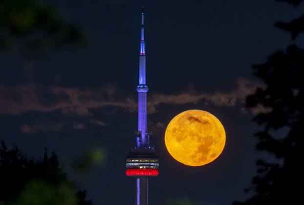 The August Super Blue Moon sets behind the CN tower in Toronto 