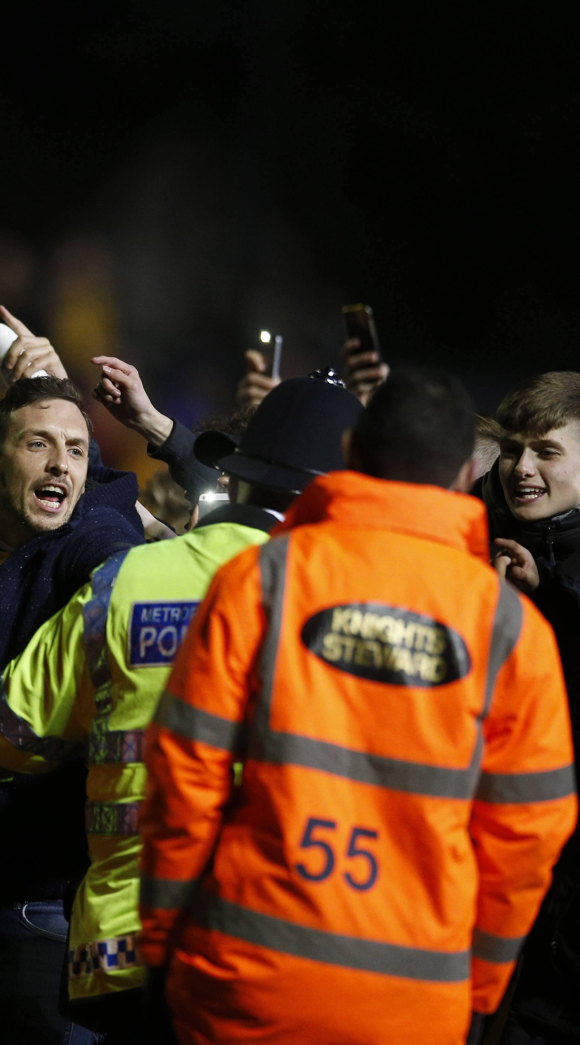 Sutton fans on the pitch with police officers after the match