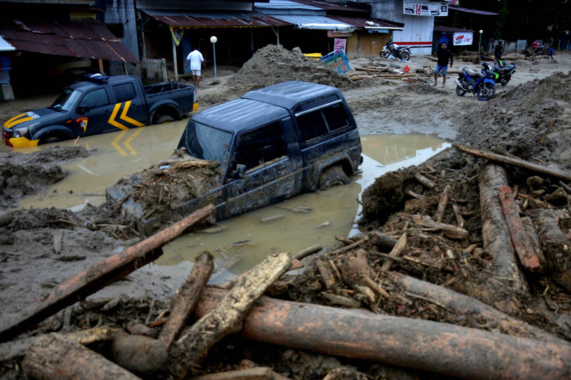 Cars are submerged in mud after flash floods swept through Radda, in North Luwu, South Sulawesi