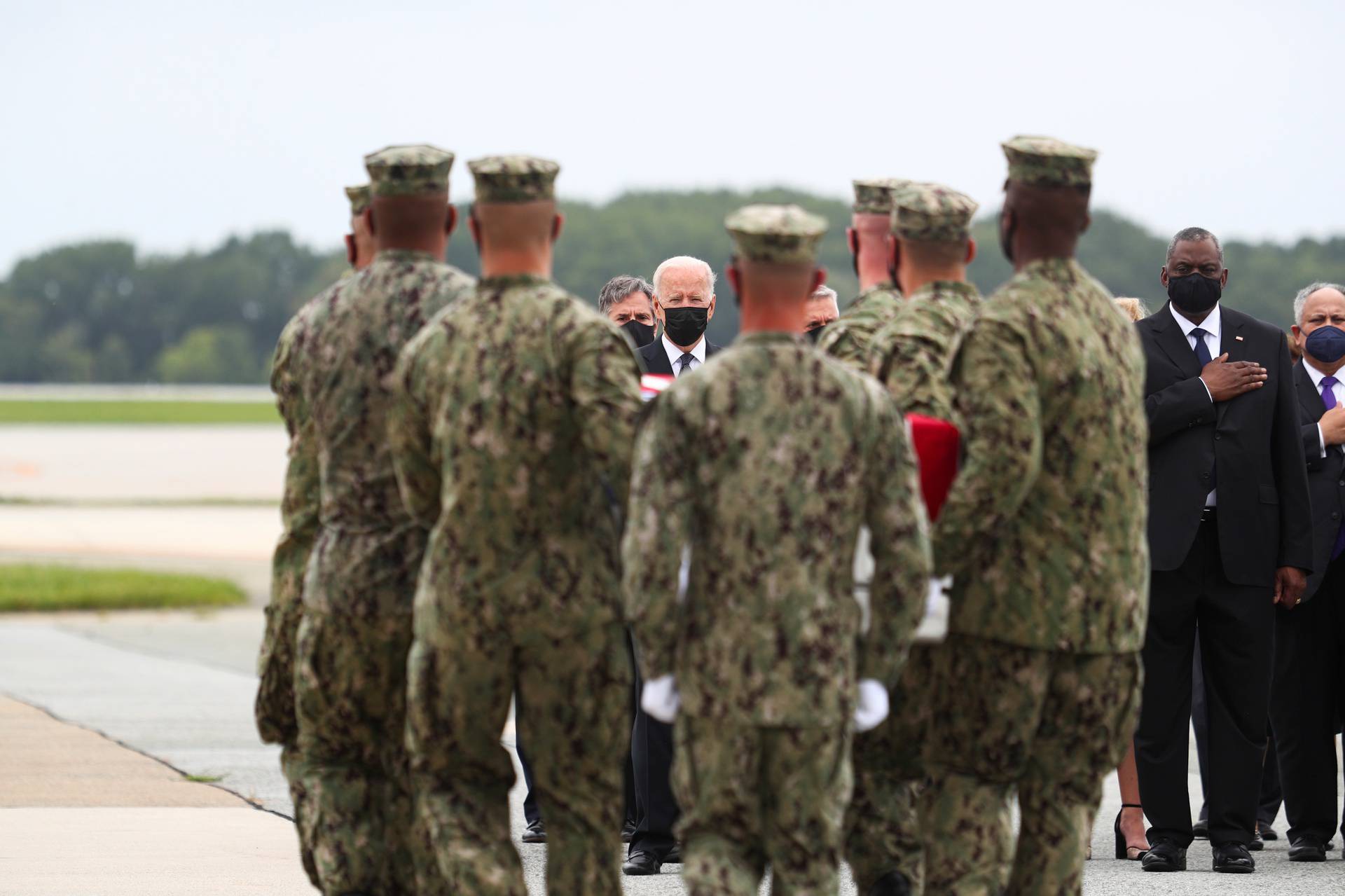 U.S. President Joe Biden salutes during the dignified transfer of the remains of U.S. Military service members who were killed by a suicide bombing at the Hamid Karzai International Airport