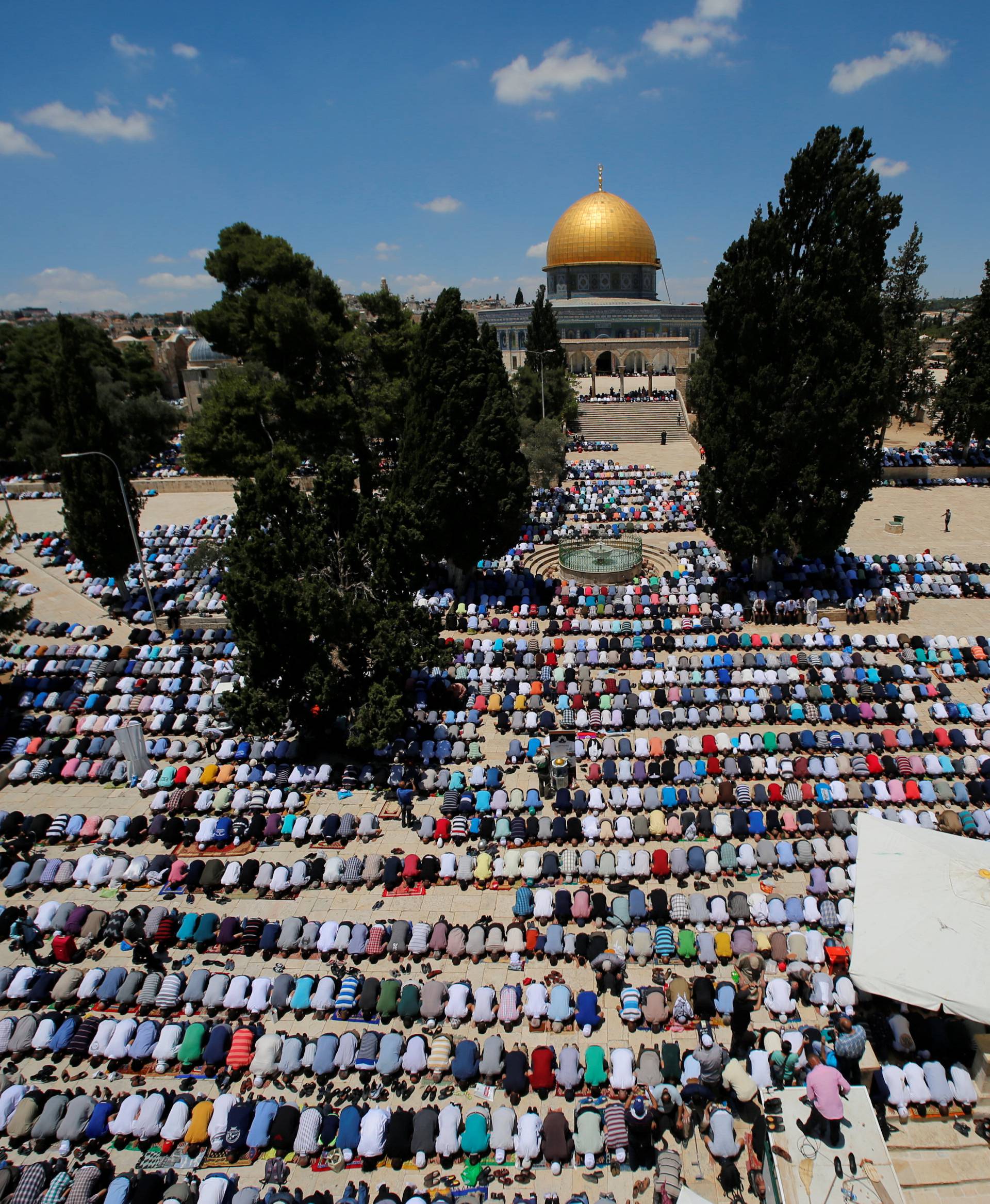 The Dome of the Rock is seen in the background as Palestinians pray on the first Friday of the holy fasting month of Ramadan on the compound known to Muslims as Noble Sanctuary and to Jews as Temple Mount in Jerusalem's Old City 