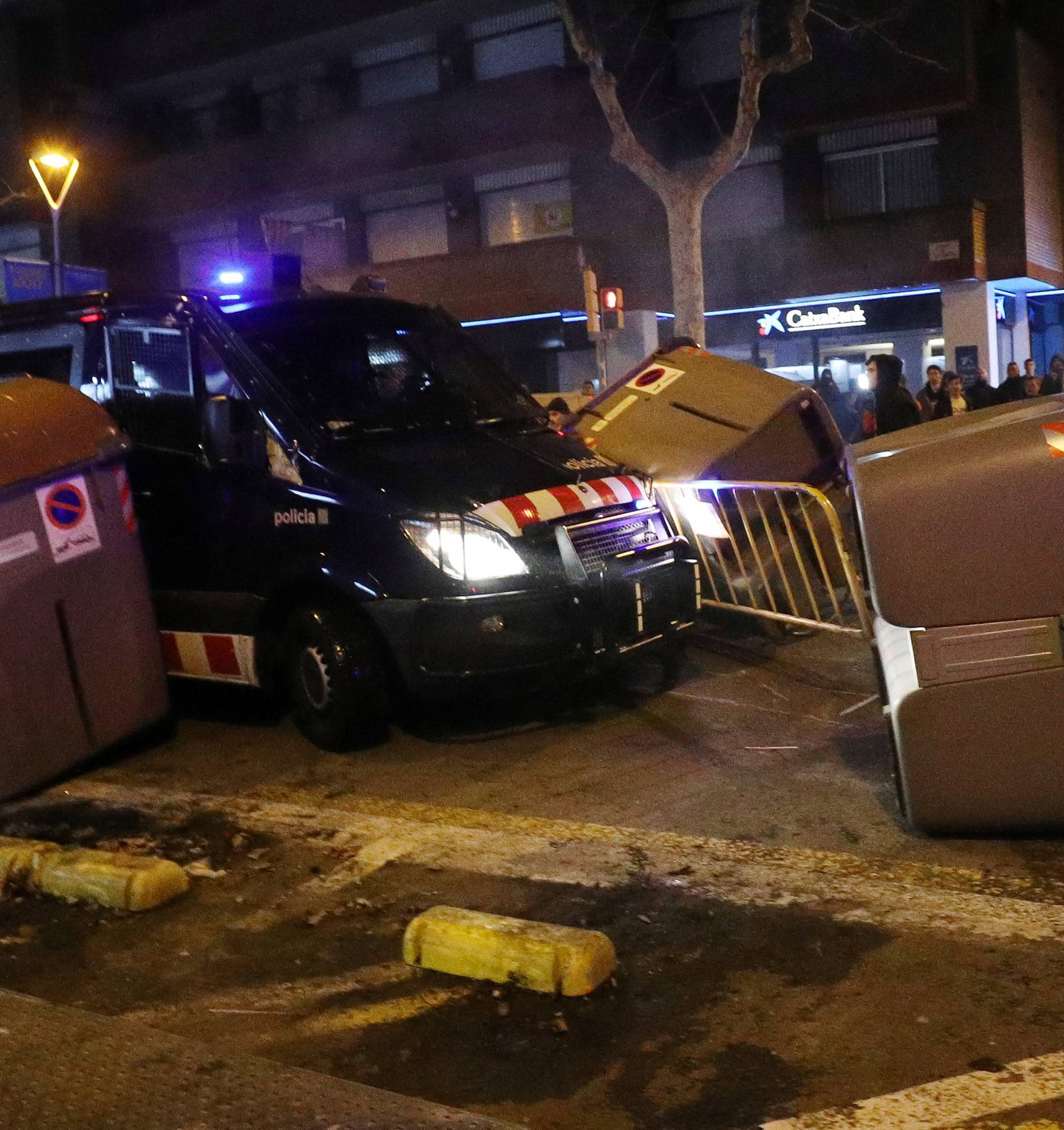 A Catalan police van drives through barricades placed by protestors during skirmishes after former regional president Carles Puigdemont was detained in Germany, in Barcelona