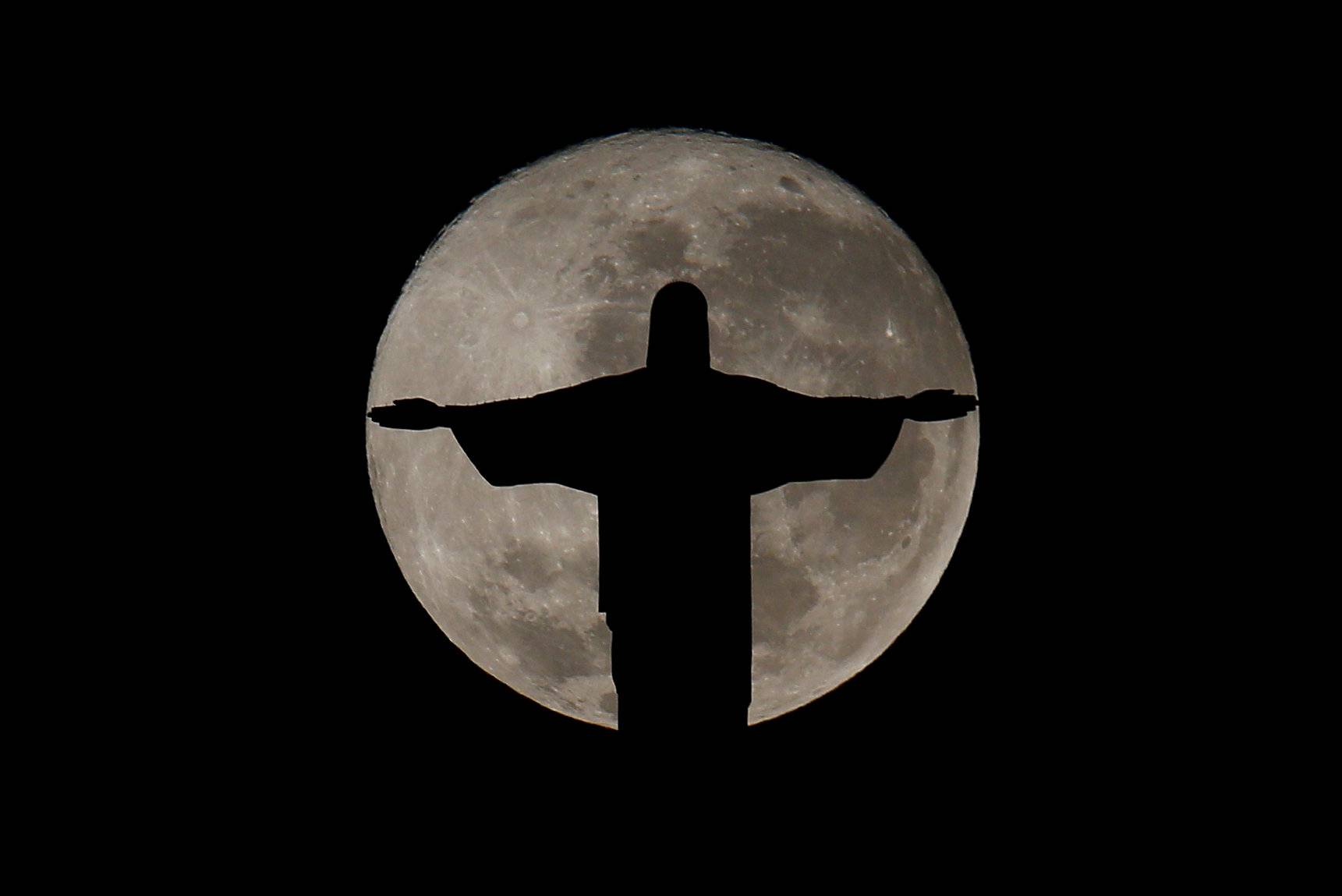 The full moon is pictured behind the Christ the Redeemer statue ahead of the 2016 Rio Olympic games in Rio de Janeiro