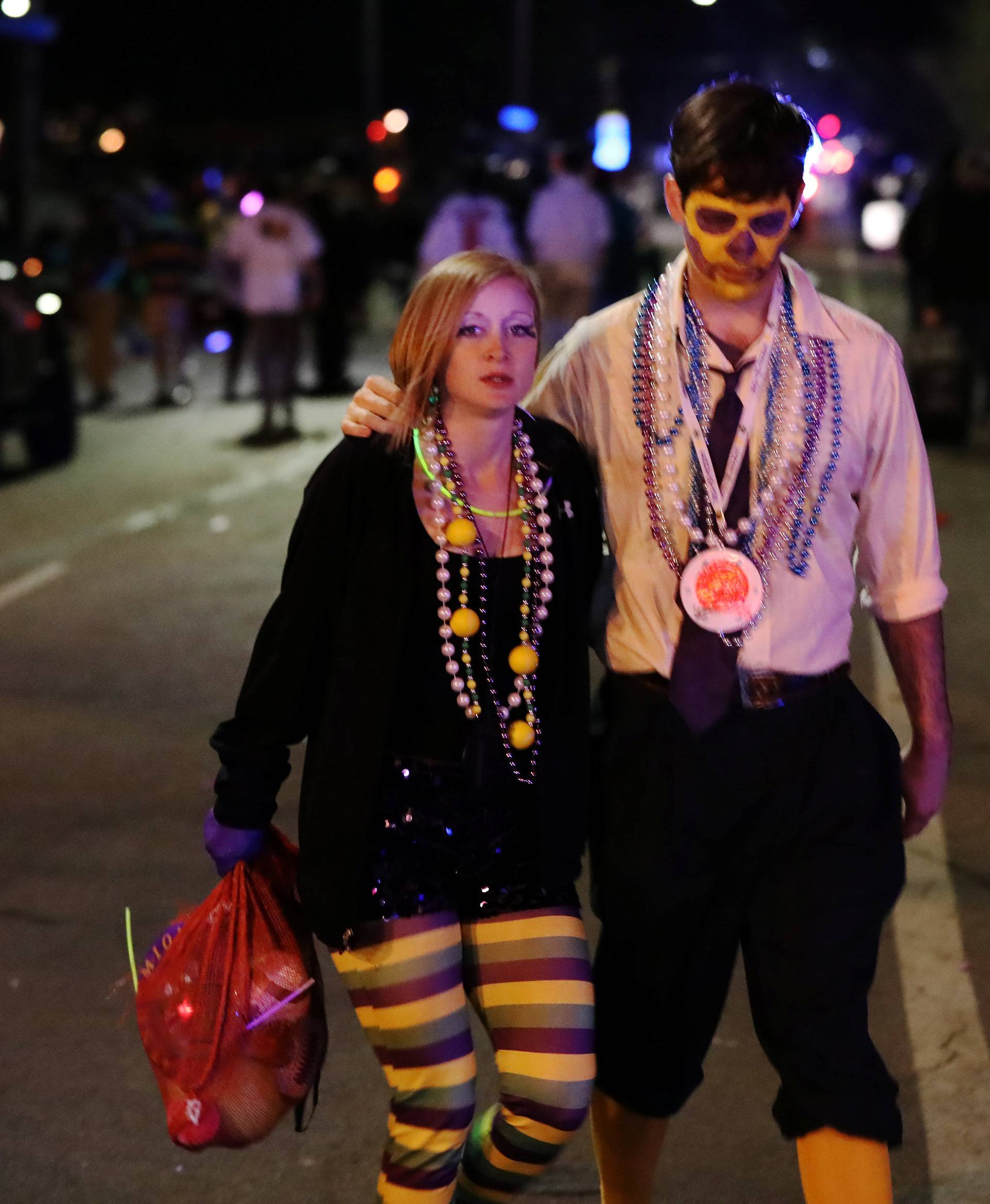 People walk away from the scene where a vehicle crashed along the Endymion parade route at Orleans and Carrollton during Mardi Gras in New Orleans, Louisiana