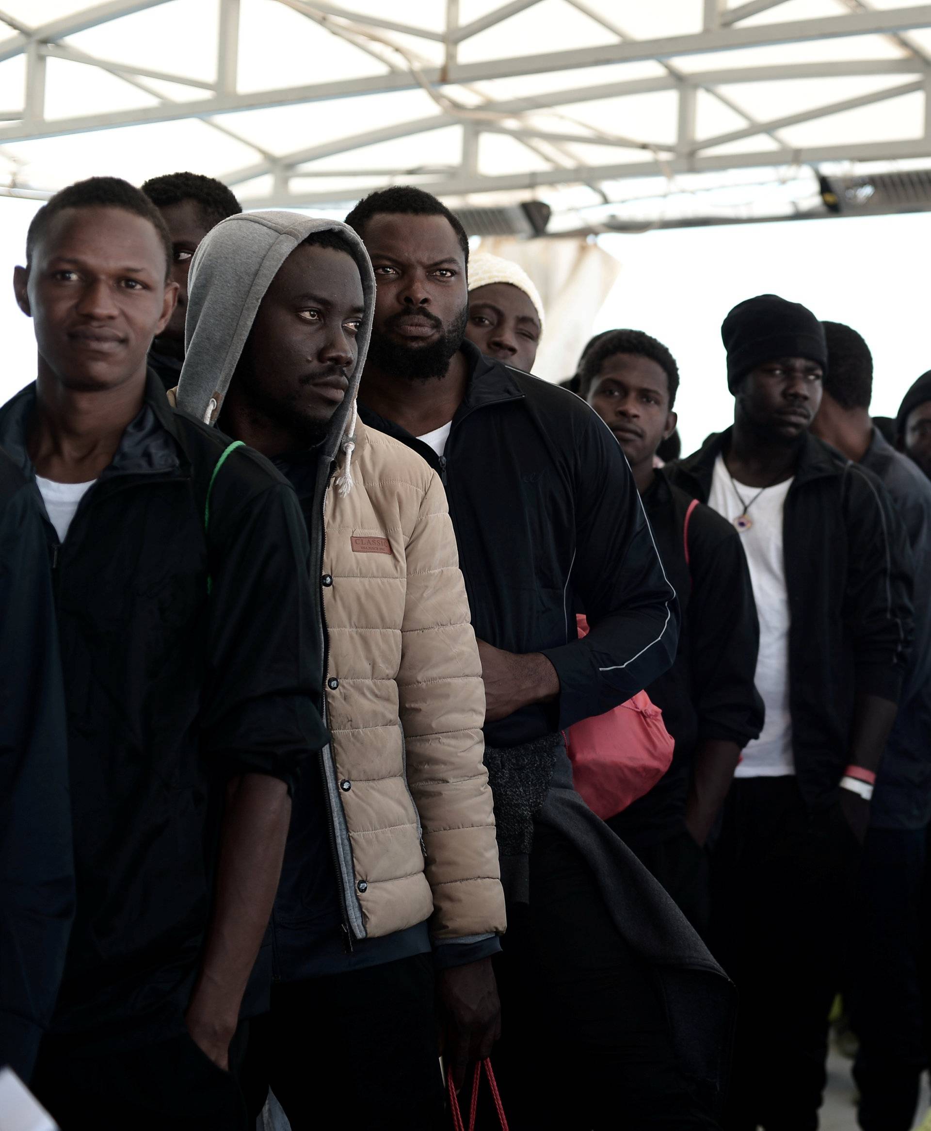 Migrants wait to disembark from the Aquarius rescue ship after arriving to port in Valencia