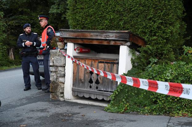 Police officers stand in front of a house where, according to police, five people were found dead in Kitzbuehel