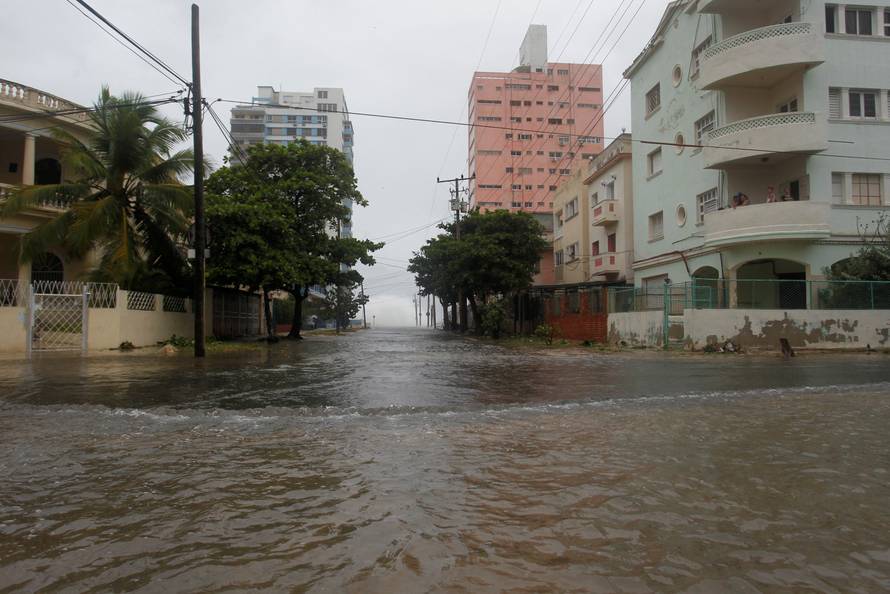 People look at the flooded street from a balcony as Hurricane Irma turns toward the Florida Keys on Saturday, in Havana
