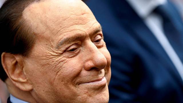FILE PHOTO: Italy's former prime minister, Silvio Berlusconi, reacts after casting his vote during Italian elections for mayors and councillors