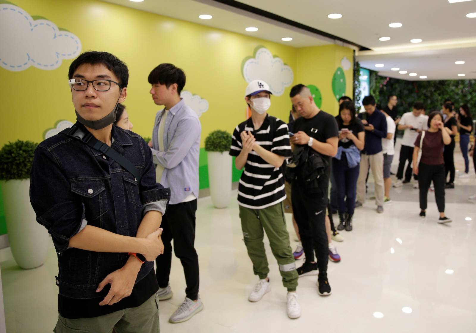Customers wait outside an Apple Store before Apple's new iPhone 11, 11 Pro and 11 Pro Max go on sale in Beijing