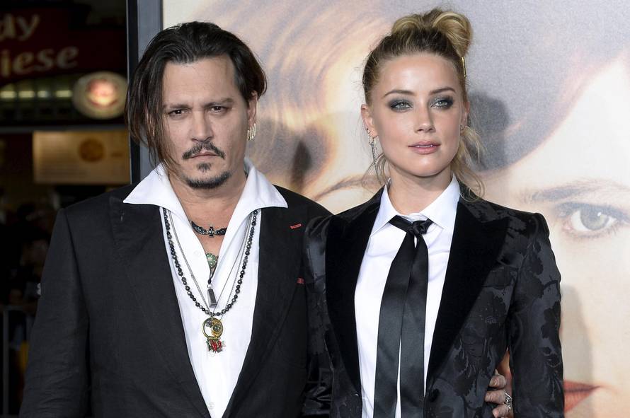 Cast member Amber Heard and husband Johnny Depp pose during the premiere of the film "The Danish Girl," in Los Angeles