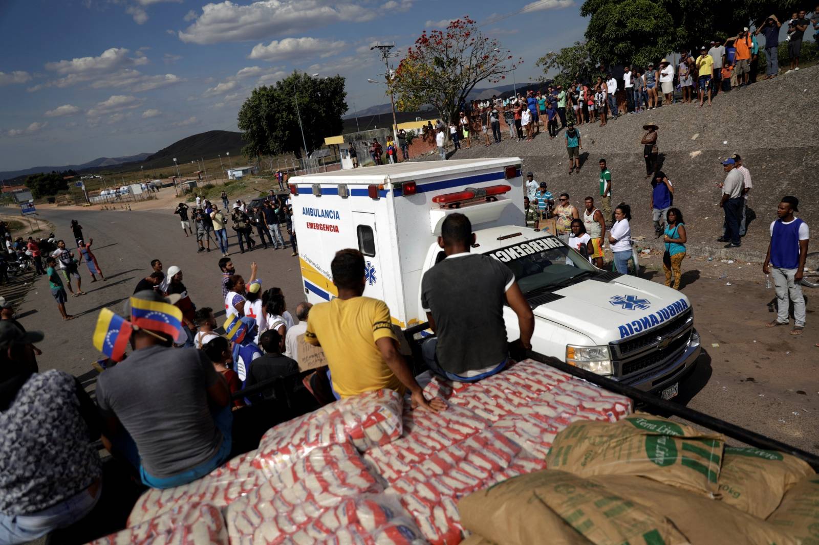 An ambulance carrying wounded people from Venezuela, passes next to a truck with humanitarian aid at the border between Venezuela and Brazil in Pacaraima