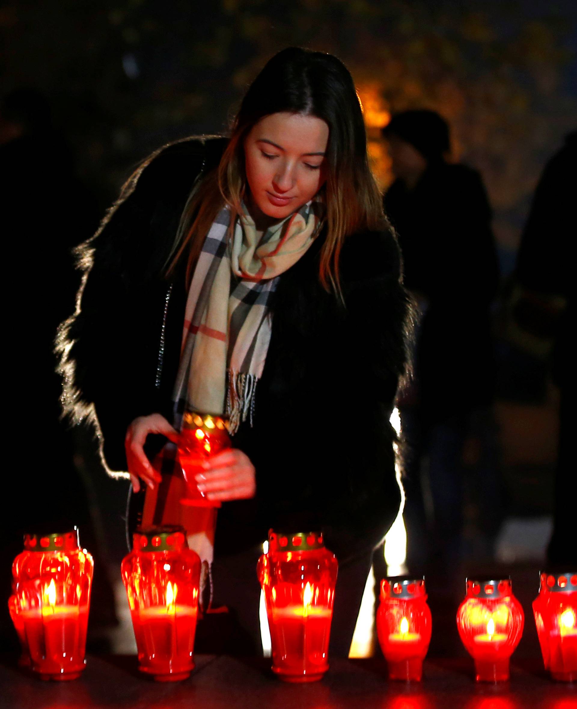 A Bosnian Croat woman lights a candle for the convicted general Slobodan Praljak, who killed himself seconds after the verdict in the U.N. war crimes tribunal in The Hague, in Mostar