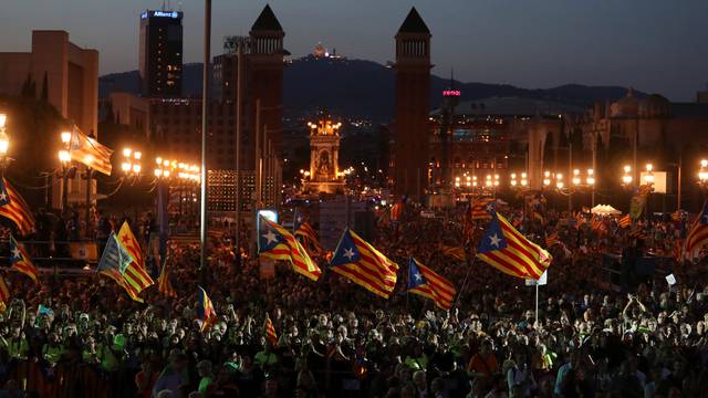 People wave Esteladas (Catalan separatist flags) as they attend a closing rally in favour of the banned October 1 independence referendum in Barcelona