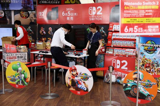 Staff members work on the day Nintendo starts selling the Nintendo Switch 2 game console globally, in Tokyo